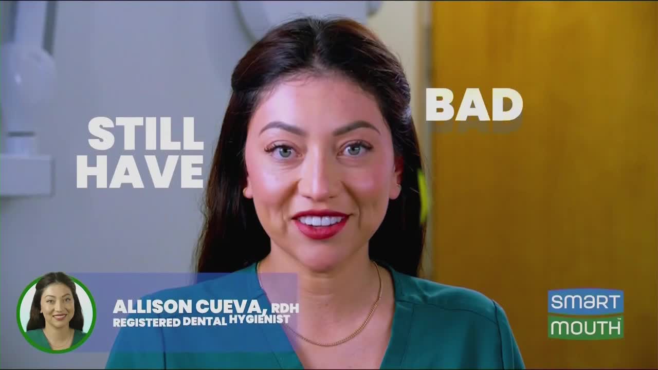A woman with dark hair smiles at the camera, her teeth bright white against red lipstick. Large white letters behind her read "STILL HAVE BAD."