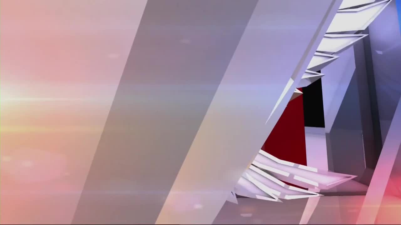 Sharp, angular planes of silver and white shift and overlap, revealing glimpses of deep red and black within.  A soft, diffused light washes over the scene, hinting at a studio setting for One America News Network.