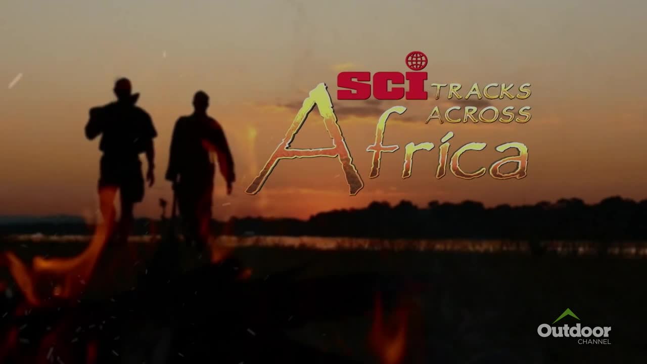 Two figures walk away from a fire, silhouetted against the sunset. The Outdoor Channel logo and "Sci Tracks Across Africa" are displayed over the scene.
