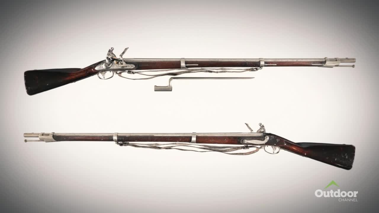 Two long rifles, with dark wooden stocks and silver-colored metal parts, are displayed against a light background. The Outdoor Channel logo is in the lower right corner.
