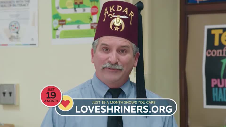 A man in a fez and tie smiles directly at the camera, a banner below him reading "LOVESHRINERS.ORG." The ad on the Pursuit Channel promotes a monthly donation of $19.
