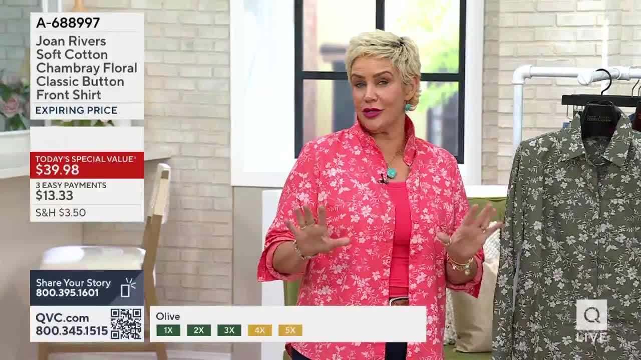 A woman in a pink floral shirt gestures with both hands, talking about a floral button-down displayed on a rack. The QVC logo is visible, along with a price tag for the shirt.
