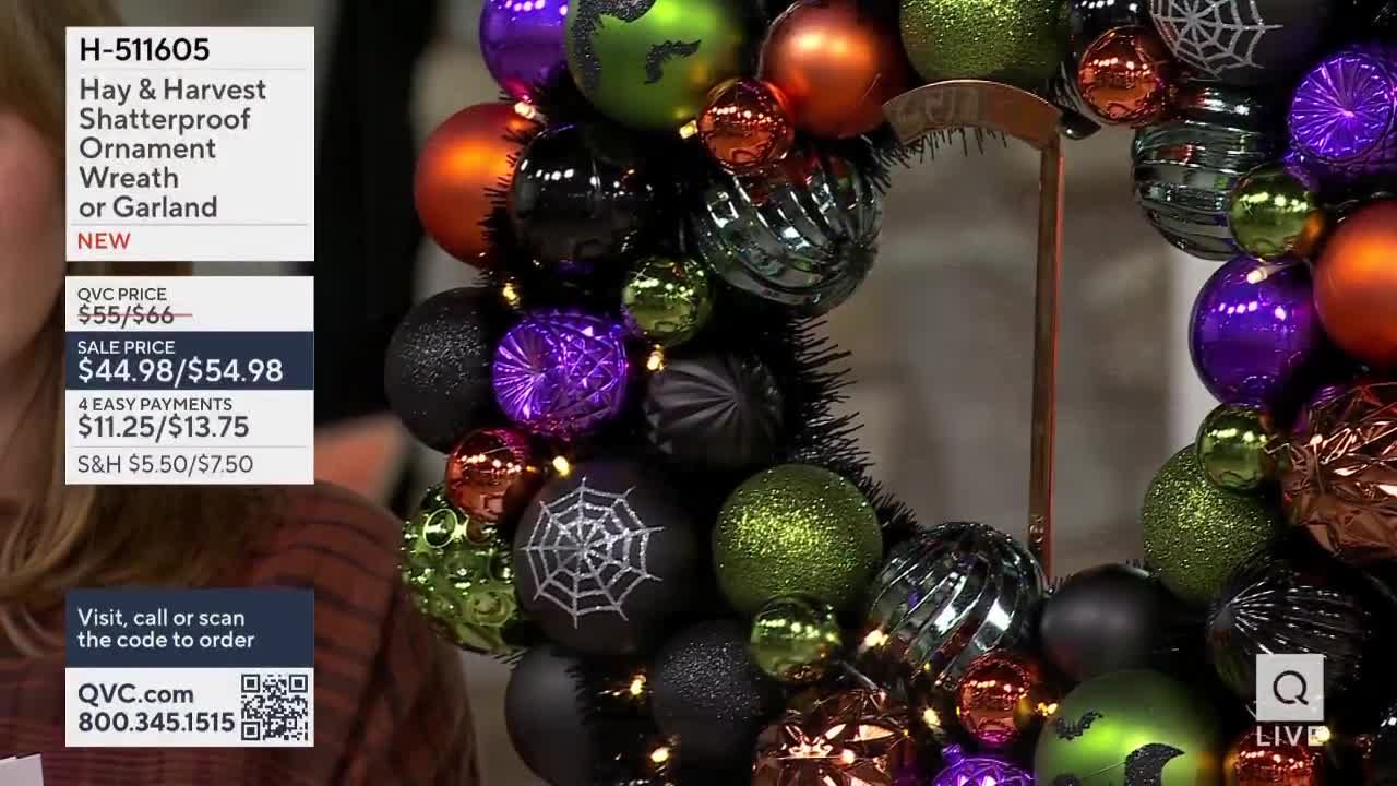 A Halloween wreath, made of shiny, colorful ornaments, is displayed on QVC. The price and ordering information are visible on the screen.
