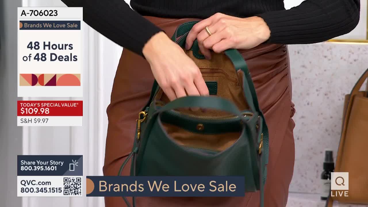 A woman reaches into a dark green handbag, pulling something out of its interior. The scene is from a QVC "Brands We Love" sale, with the "Today's Special Value" price displayed on screen.
