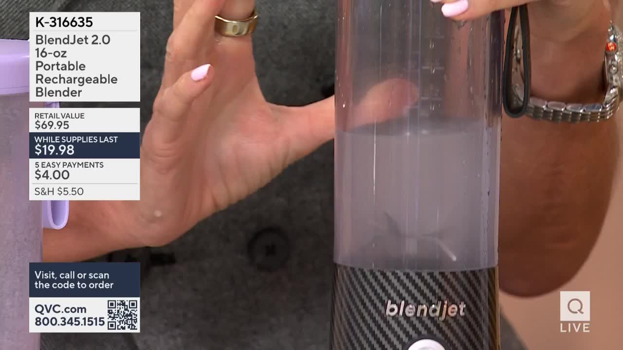 A woman holds a portable blender, demonstrating it on a QVC broadcast. The blender's contents are swirling, and the blades are visible inside the clear container.
