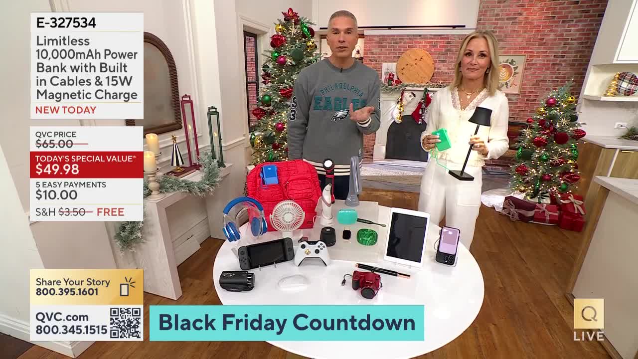 A man in a Philadelphia Eagles sweatshirt gestures towards a table covered with gadgets, while a woman holds a small lamp and a green charger. The QVC set is decorated for the holidays, and a "Black Friday Countdown" graphic appears on the screen.
