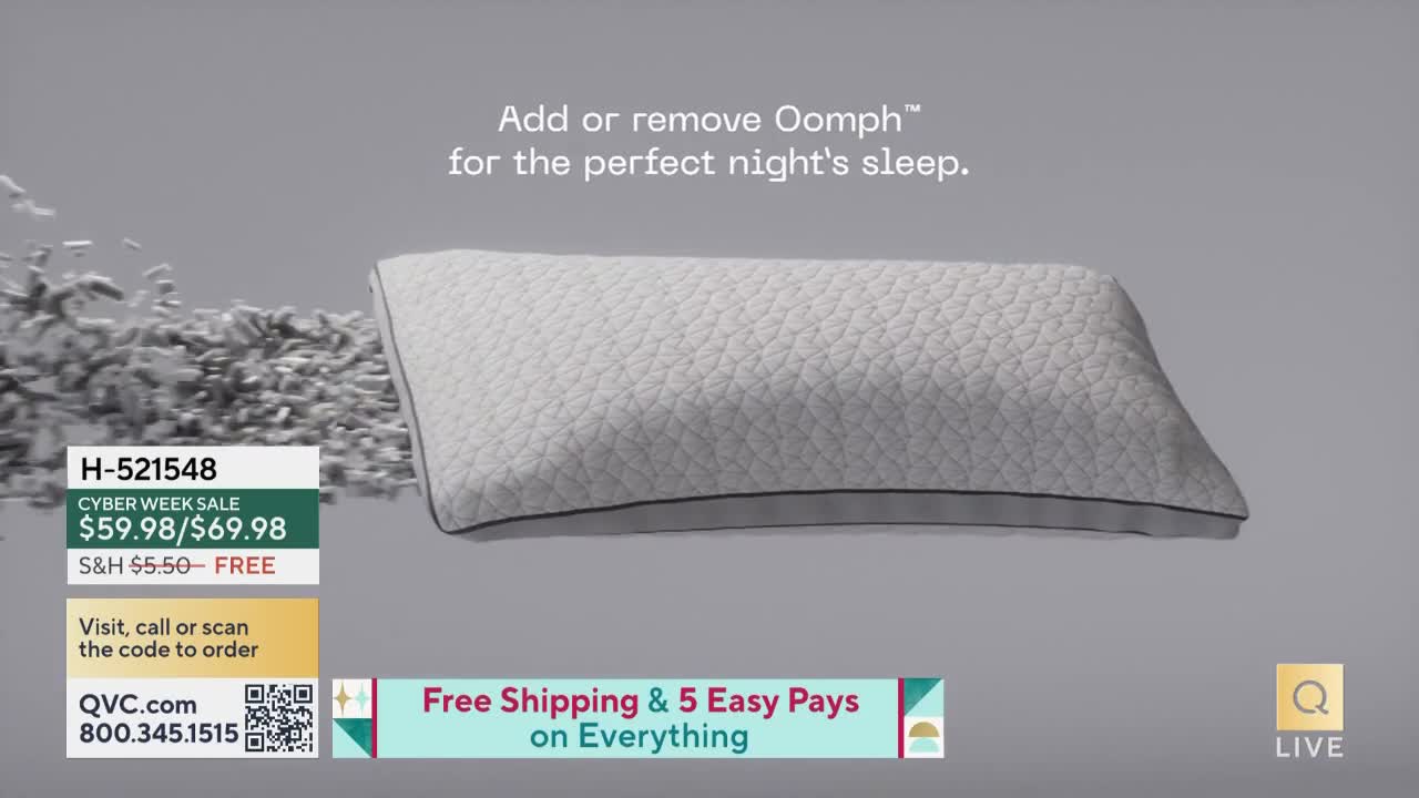 A fluffy pillow floats against a gray background, with what looks like small, white pieces rising from the left. Below, a QVC graphic displays the product's price and ordering information.
