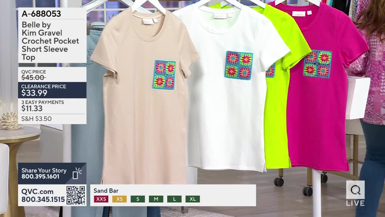 Four t-shirts hang on a rack, each with a colorful, crocheted square on the chest pocket. A woman in a patterned top stands to the right, her arm extended.