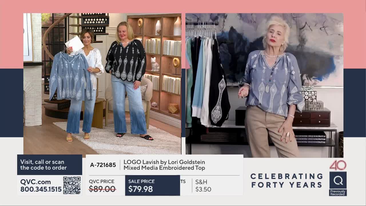 A woman holds up a light blue, tie-dye style top while another woman stands beside her, both wearing wide-leg jeans. A third woman, wearing a similar blue top, gestures to the camera.