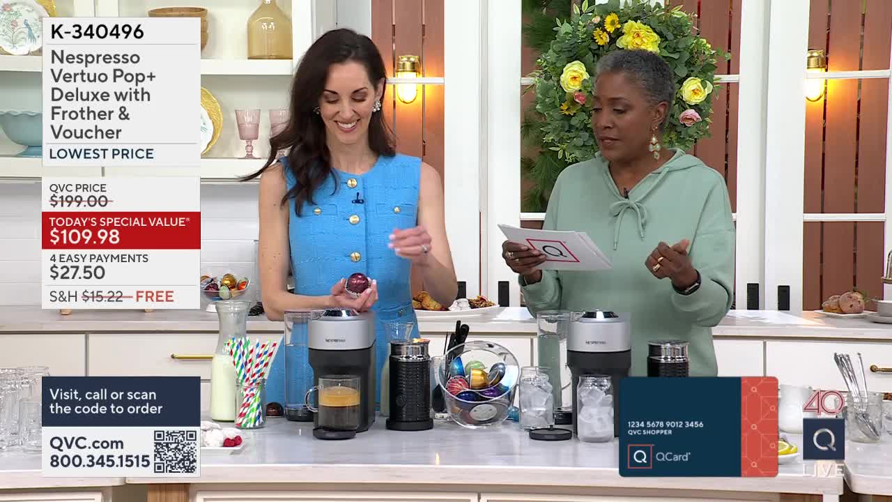 A woman in a blue dress holds a red coffee pod, about to place it into a Nespresso machine. Another woman in a mint green hoodie reads from a card, gesturing as she speaks.