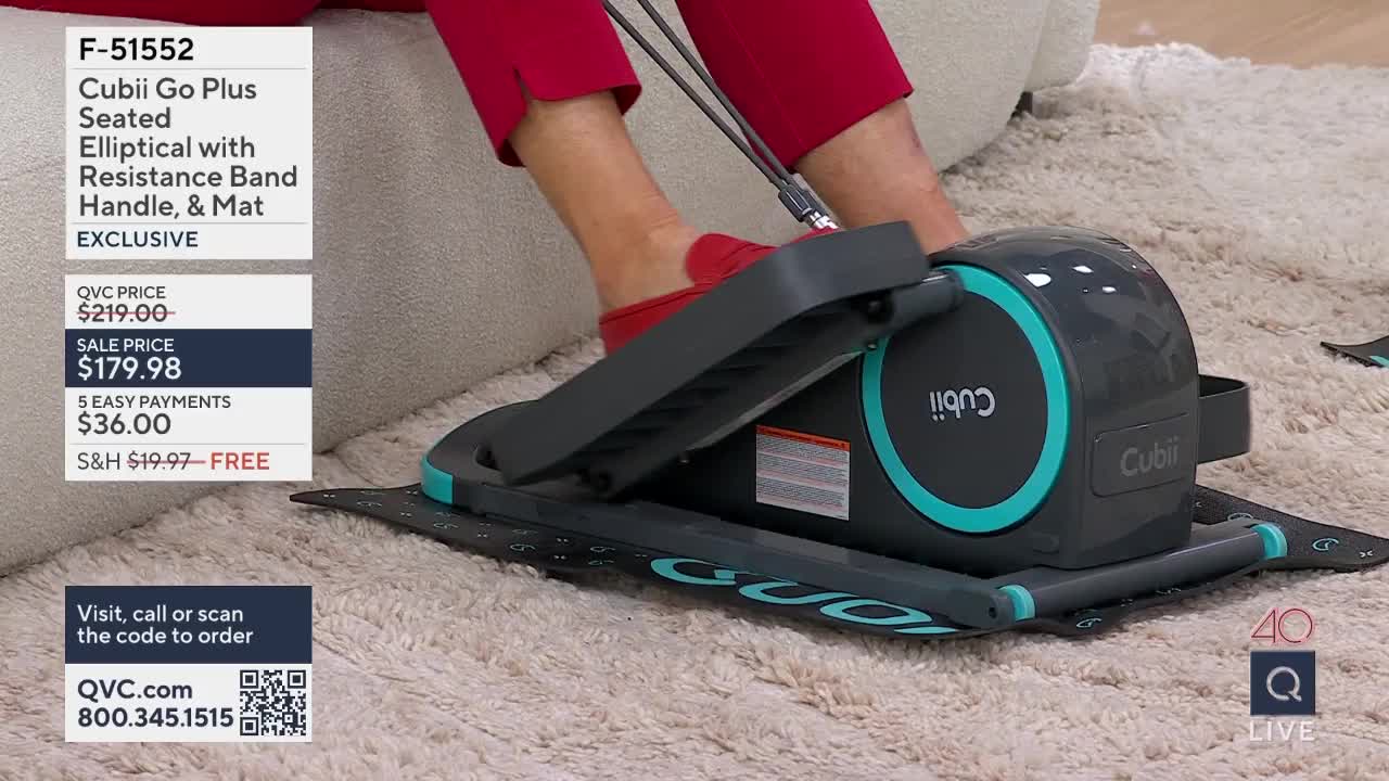 A person's feet in red slippers move back and forth on a compact elliptical machine. The machine, a Cubii Go Plus, sits on a textured mat on a carpeted floor.