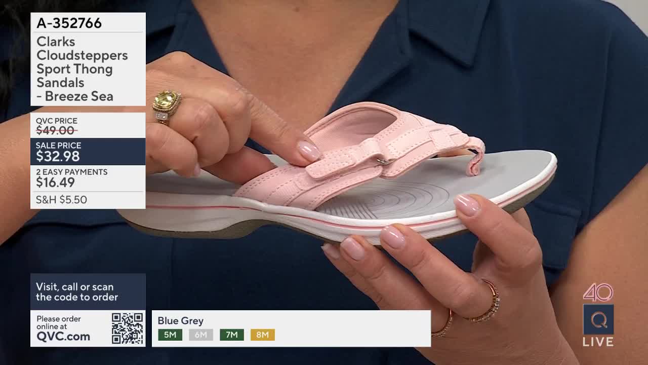A woman's hands adjust the strap on a pale pink Clarks sandal. The QVC logo and product details are visible on screen.