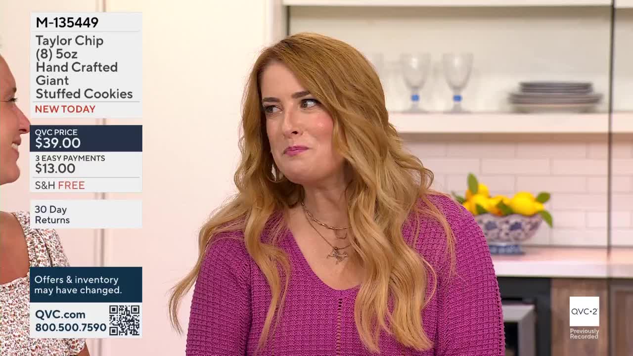 A woman with long, wavy hair glances to her left, her expression a mix of surprise and amusement. The QVC2 logo is visible in the corner, and the screen displays information about cookies.
