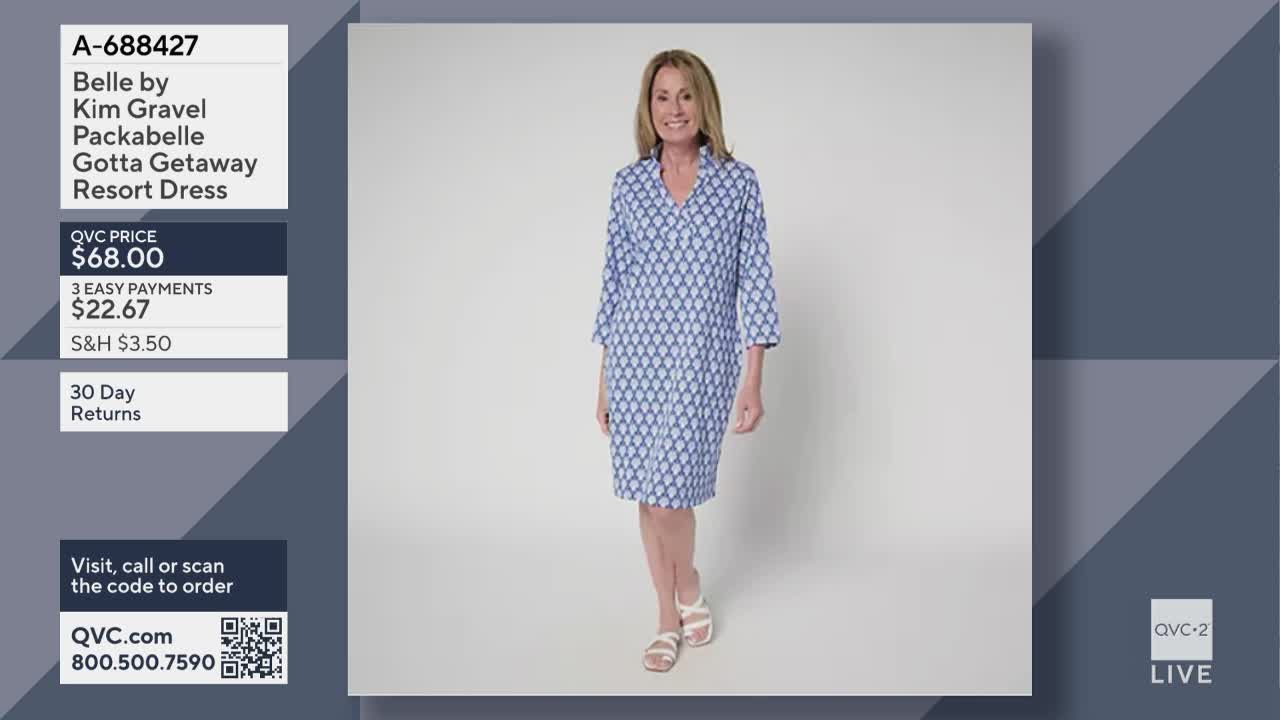 A woman in a blue patterned dress stands in front of a white backdrop. The QVC2 logo is visible in the corner, and the price of the dress is listed on the screen.
