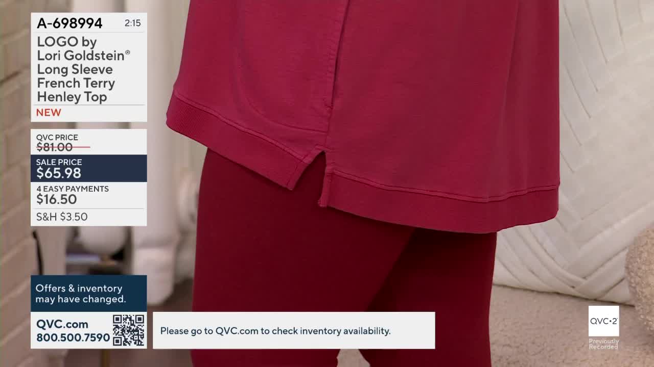 A woman is wearing a deep red Henley top and matching leggings. The camera focuses on the bottom hem of the top and the side slit, showing the fabric's texture.
