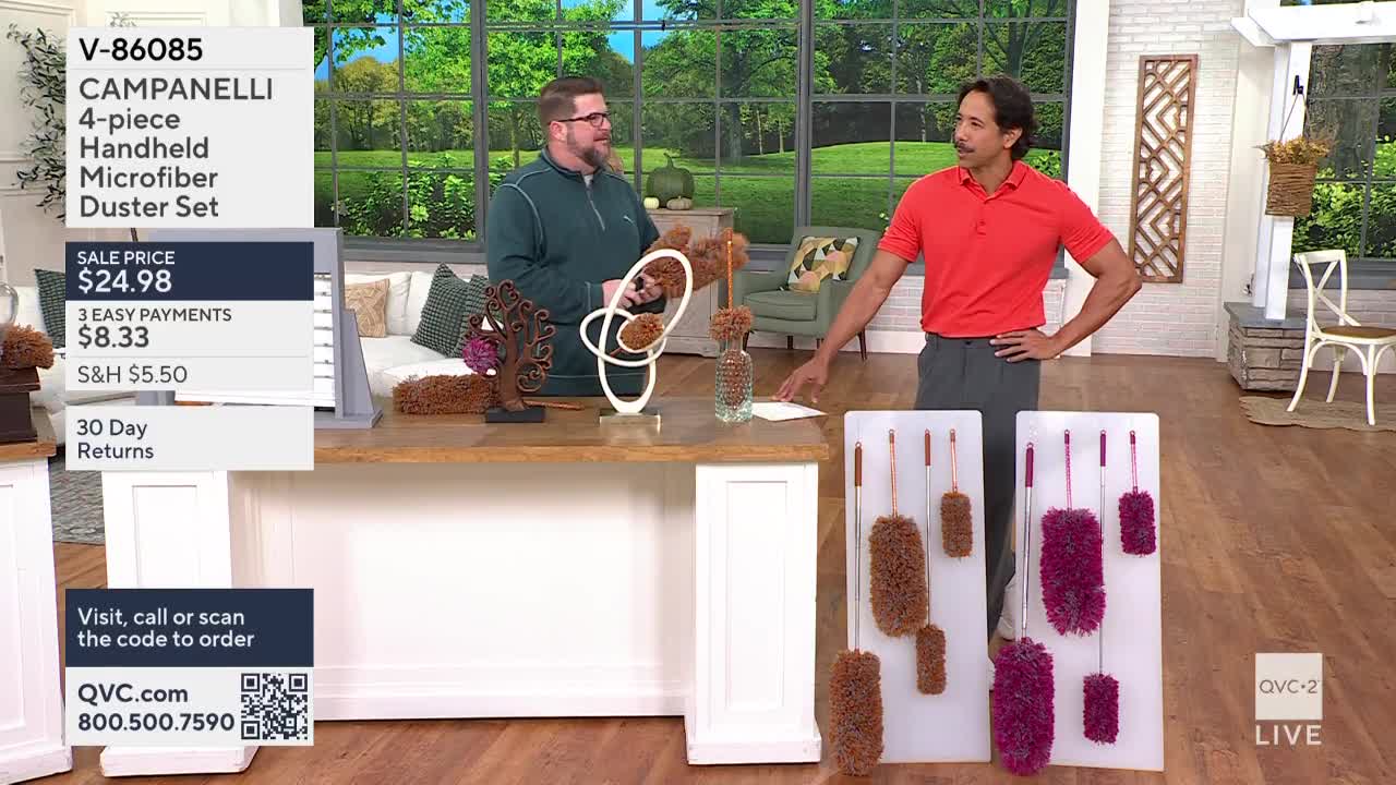Two men stand behind a table on QVC2, one holding a brown duster and the other gesturing toward a display of the same product. The camera focuses on the dusters, with their sale price and payment options displayed on a screen.
