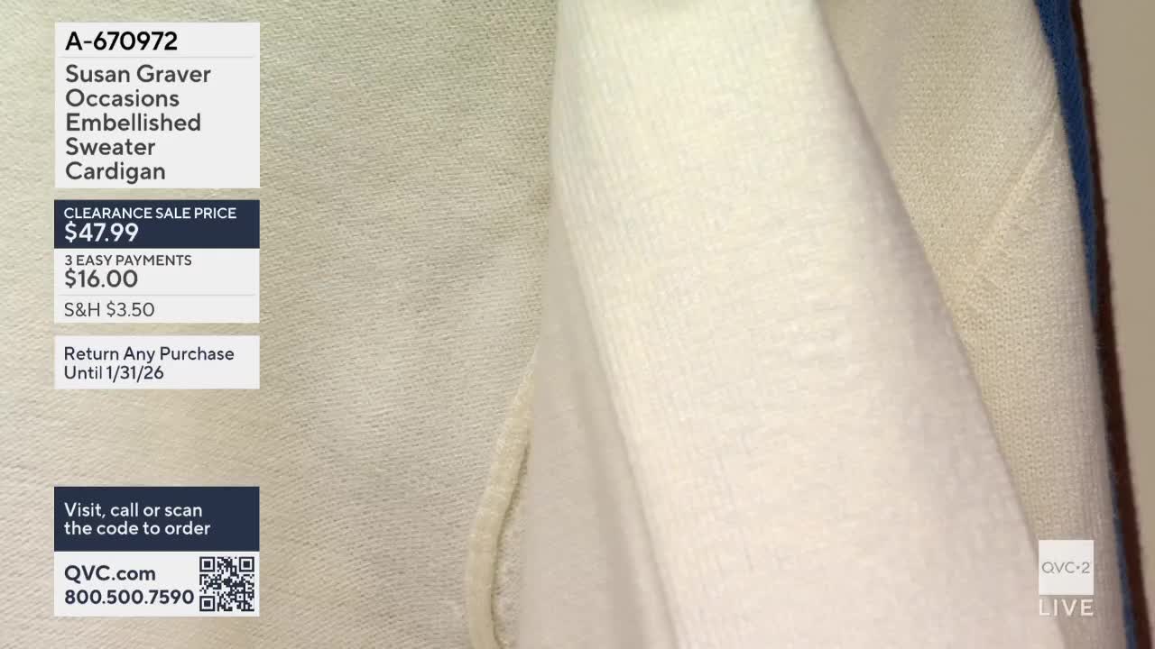 A close-up of a cream-colored sweater cardigan fills the frame. The fabric is folded and draped, with the edge of a blue garment visible on the right.
