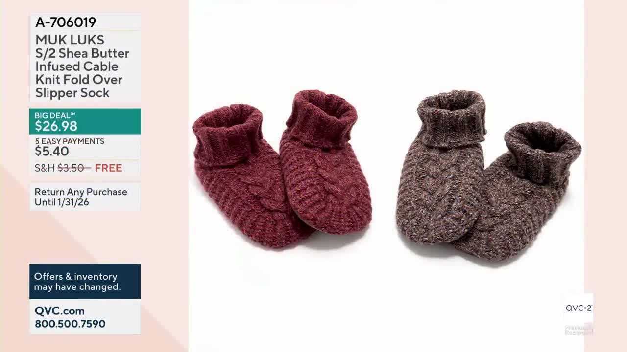 Two pairs of cable-knit slipper socks sit on a white background, one in a deep burgundy and the other in a speckled brown. The QVC2 logo is visible in the corner.
