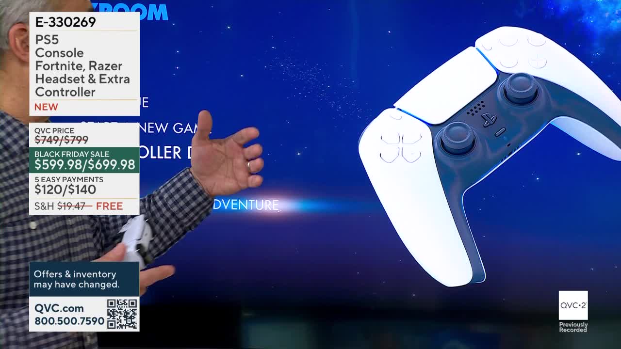 A man in a checkered shirt gestures toward a large white and black game controller on a blue background. The QVC2 logo is in the bottom right corner, and text details a Black Friday sale for a PS5 bundle.
