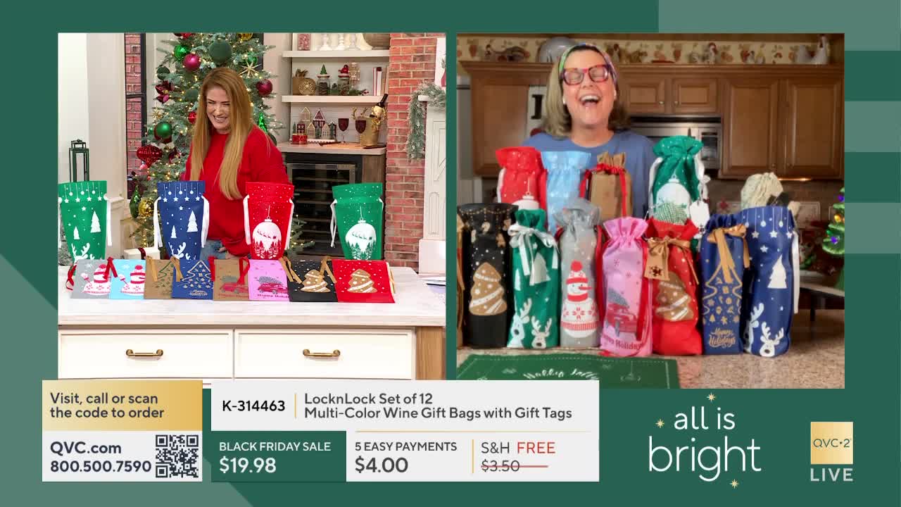 On a split screen for QVC2, two women are smiling, each surrounded by colorful Christmas-themed wine bags. The bags are arranged on a table and kitchen counter, ready for holiday gift-giving.
