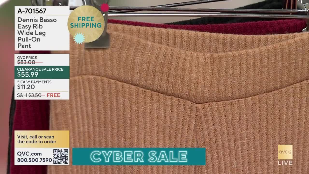 Three pairs of ribbed knit pants hang on a rack, one in a tan color taking center stage. The QVC2 logo and "Cyber Sale" text are visible at the bottom of the screen.
