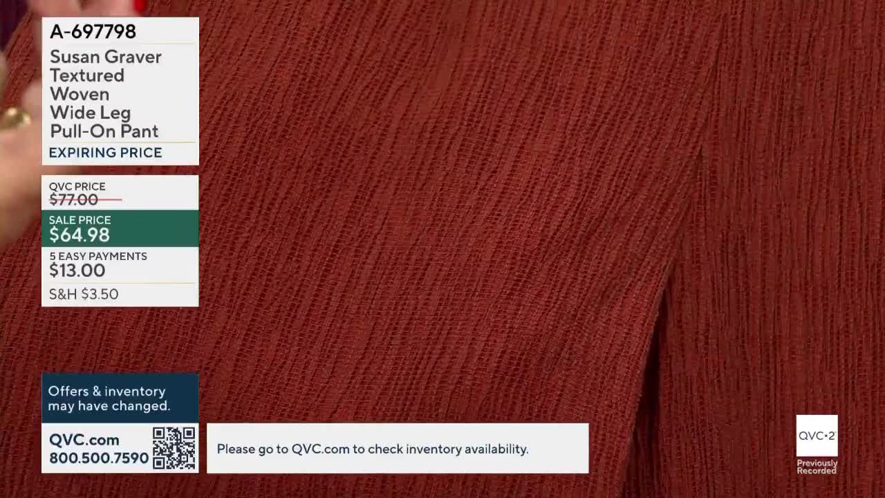 A close-up of textured, rust-colored fabric fills the screen, likely a garment being presented on QVC2. The price and product details are displayed in the corner, and the bottom right corner shows the QVC2 logo.
