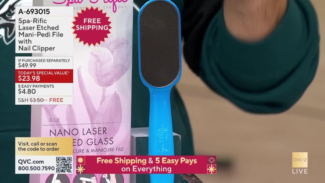 A bright blue foot file is held up against a product display on QVC2. The screen shows the price and details of the Spa-Rific Laser Etched Mani-Pedi File.
