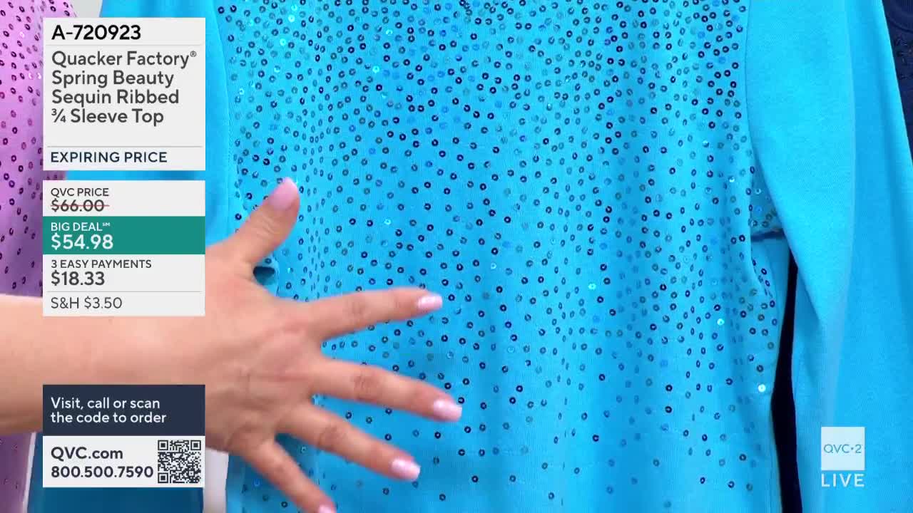 A hand gently sweeps across a bright blue top covered in small, shimmering sequins. The QVC2 logo and pricing information are displayed on the left side of the screen.