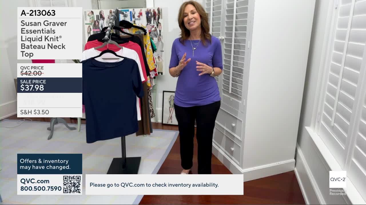 A woman in a purple top stands on a wooden floor, gesturing with her hands. To her left, a navy blue top hangs on a display stand.