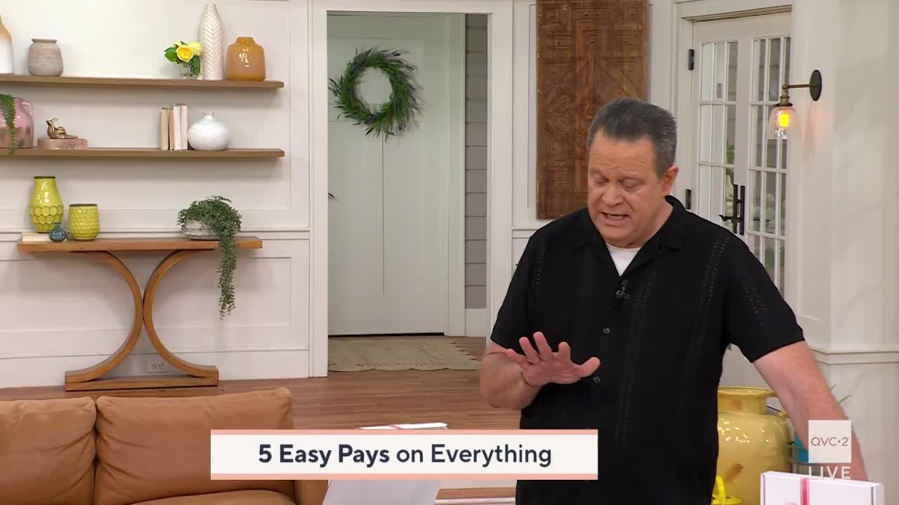 A man gestures with his hands, speaking animatedly in front of a set decorated with shelves of vases and a wreath. A graphic overlay reads "5 Easy Pays on Everything," indicating a QVC2 broadcast.
