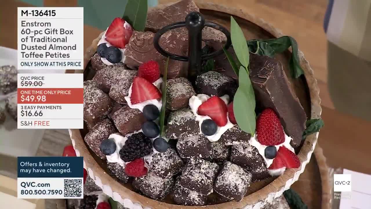 The Enstrom 60-piece gift box of dusted almond toffee petites is on display. Fresh berries and whipped cream top the chocolates.