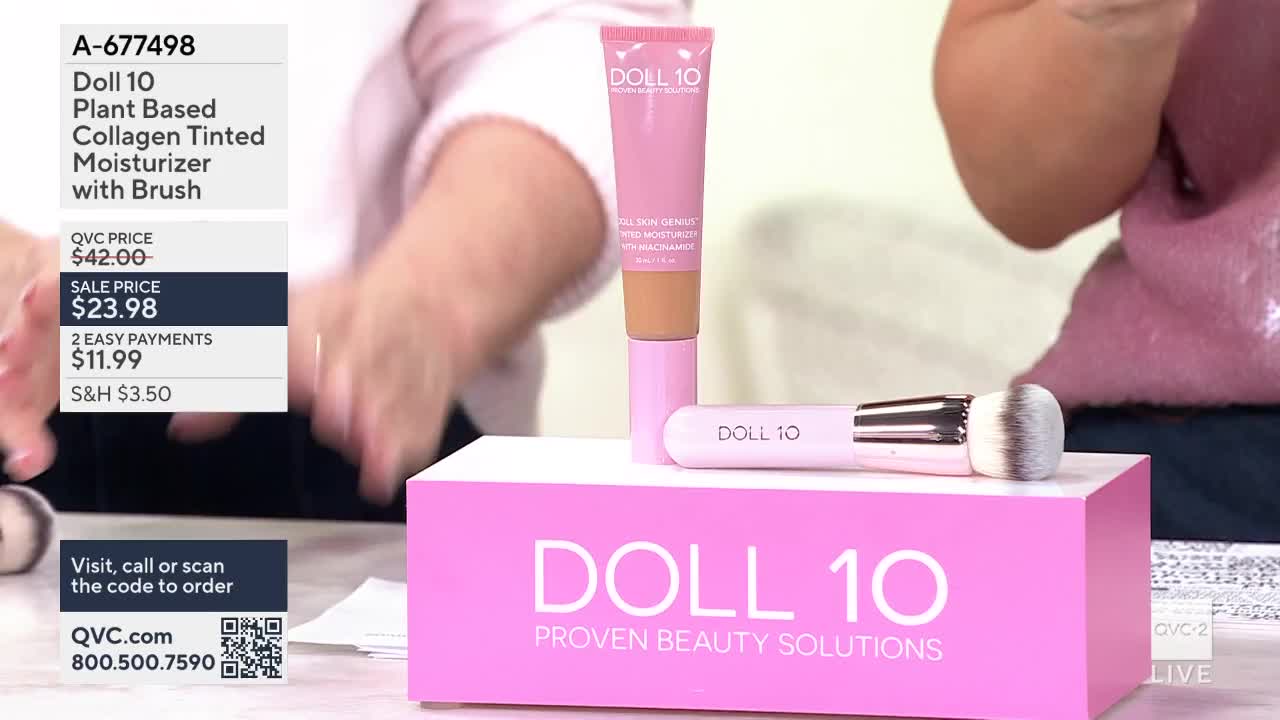 A pink tube of Doll 10 moisturizer stands tall, with a matching brush resting beside it on a bright pink display. The QVC logo is visible on the screen, indicating this is a product demonstration.