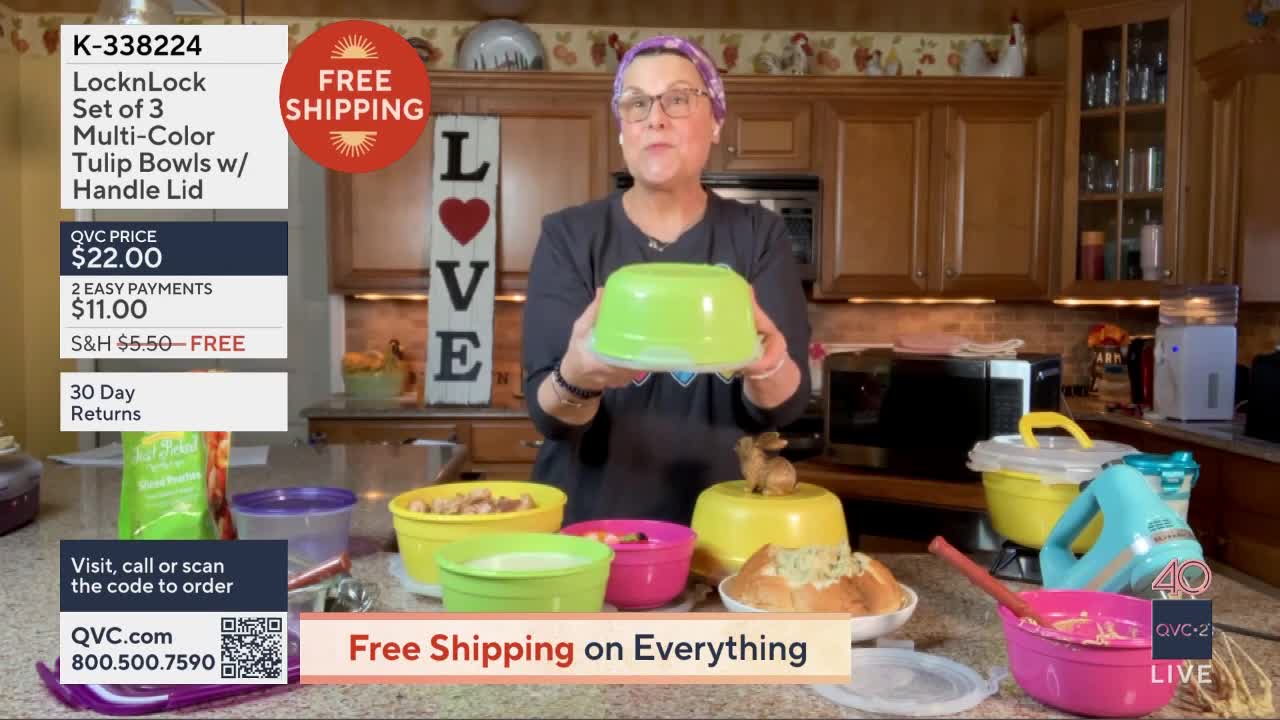 A woman holds up a bright green bowl with a clear lid, presenting it to the camera. Around her, a collection of colorful bowls, some filled with food, are arranged on a counter.