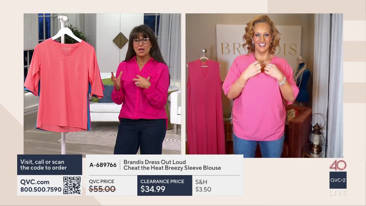 A woman in a bright pink blouse gestures animatedly while a coral-colored top hangs on a rack beside her. To her right, another woman smiles and adjusts the neckline of her own pink top.