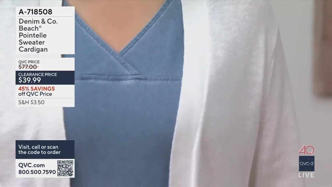 A woman models a light blue V-neck top with a white open cardigan over it. The QVC2 logo and product details are displayed on the left side of the screen.