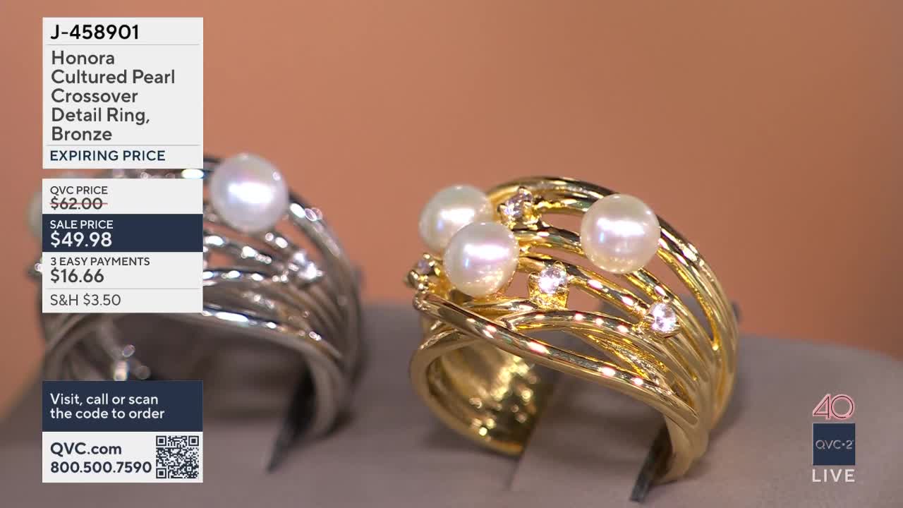 A gold ring with four pearls and small diamonds sits on display. Next to it, a silver ring with a single pearl is also presented.