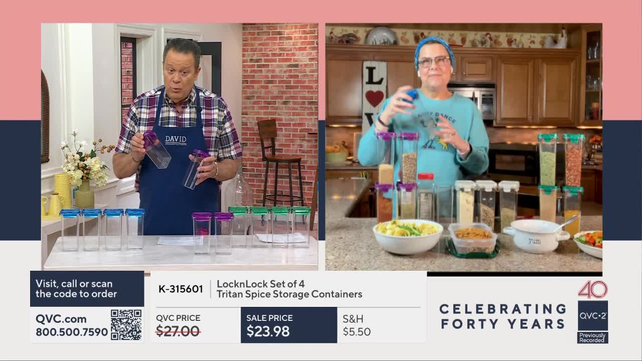 A man in an apron holds up two clear spice containers with purple lids, demonstrating them for the camera. Beside him, a woman in a blue sweatshirt stacks similar containers filled with spices.