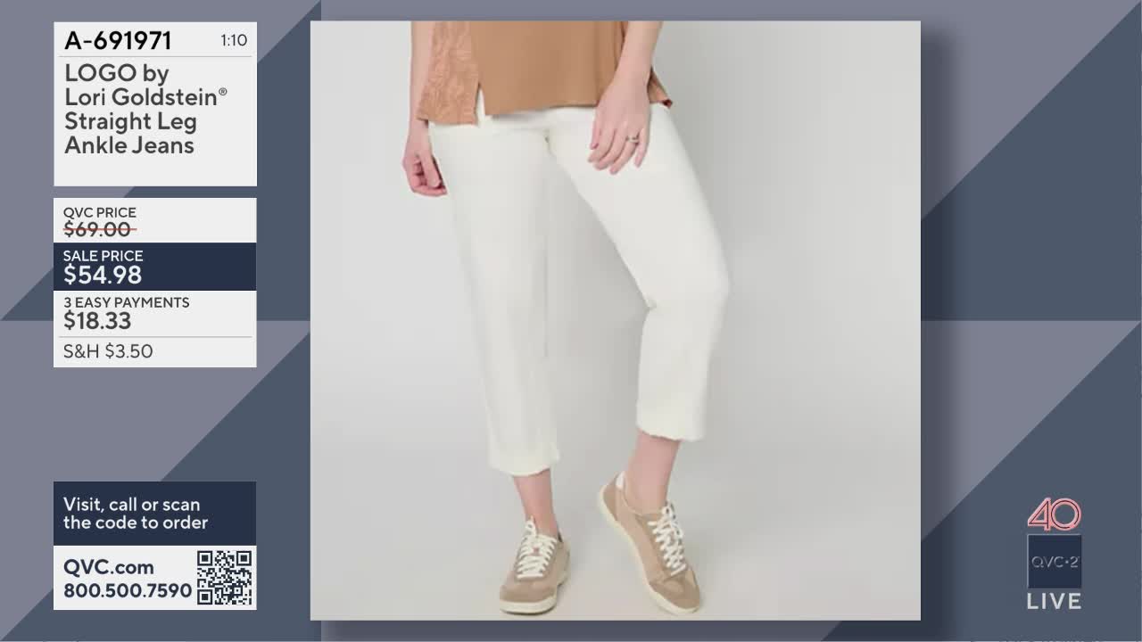 A woman stands with her legs slightly apart, showcasing a pair of off-white, straight-leg ankle jeans. She wears tan sneakers with white laces that match the light brown of her top.