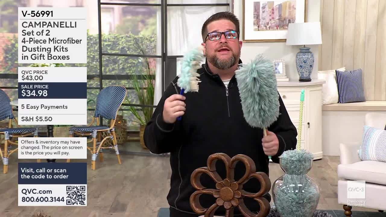 A man on QVC3 in the United States holds up two fluffy dusters, demonstrating their use. The on-screen text advertises the dusting kits for sale.
