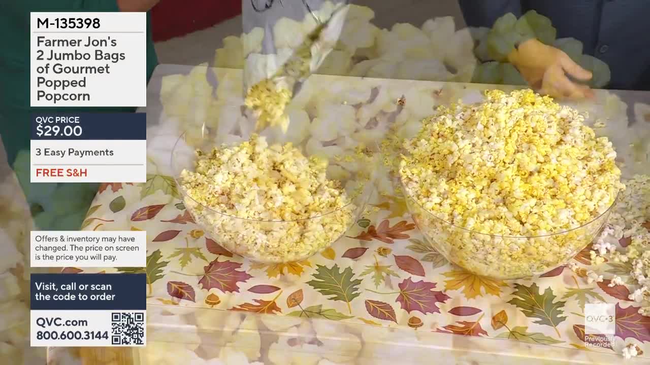 On QVC3, a person is pouring a mountain of yellow popcorn into a clear bowl. The table is covered in a fall-themed tablecloth, and another bowl is already filled.

