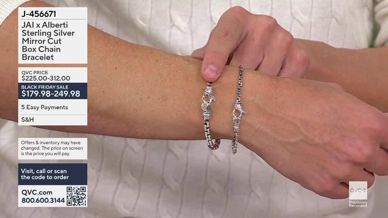 A hand holds two silver bracelets side-by-side, showcasing the jewelry. The bracelets, with intricate clasps, are displayed against the backdrop of a white sweater on QVC3.
