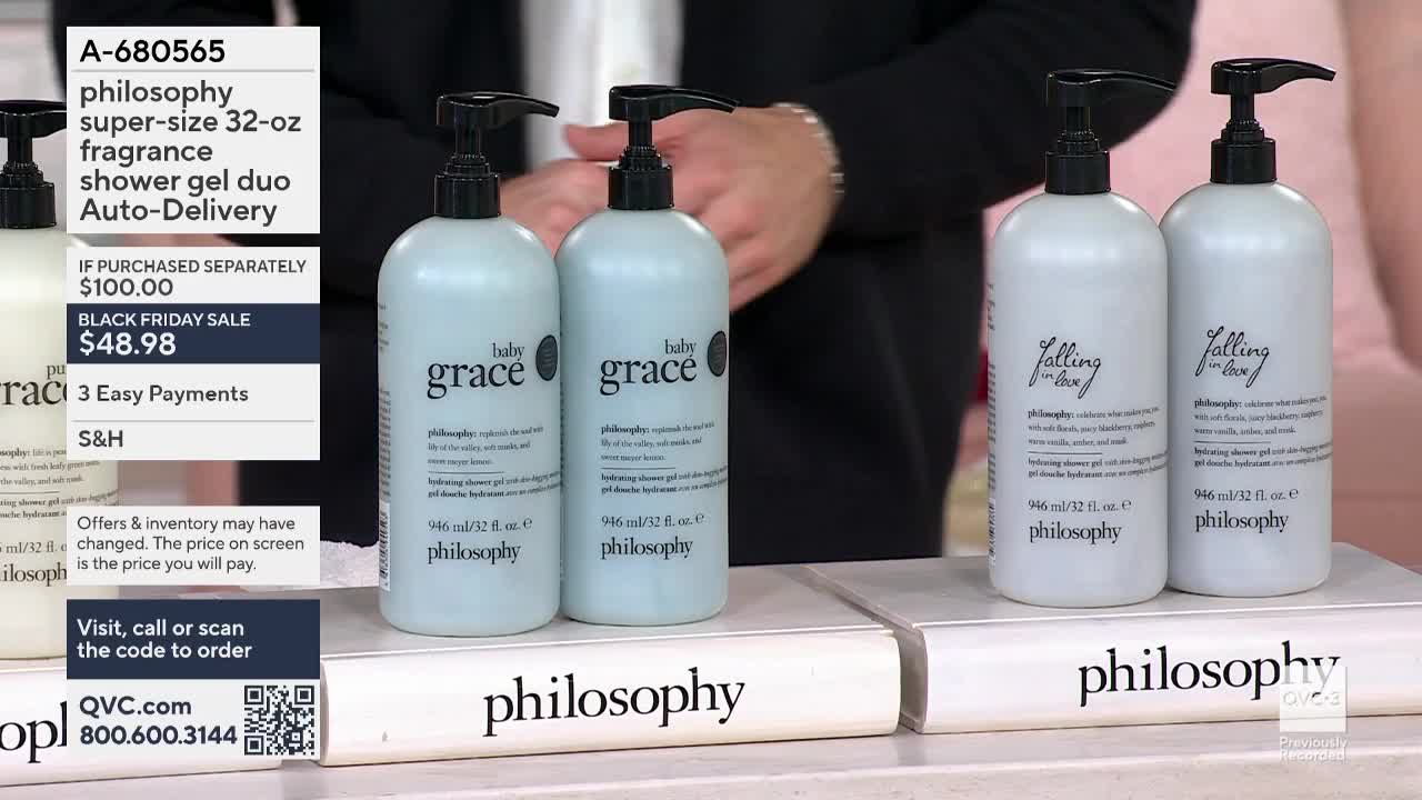 On QVC3, the host is showcasing several bottles of "philosophy" shower gel, arranged neatly on white display blocks. The bottles, with black pumps, are labeled "baby grace" and "falling in love."
