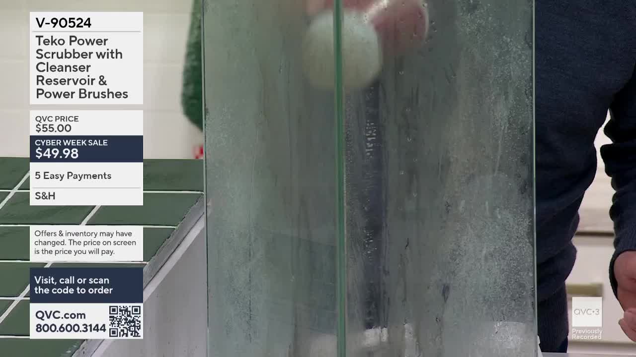 A power scrubber, advertised on QVC3, is being used on a glass panel, and the surface is visibly wet. The product demonstration is taking place in the United States.

