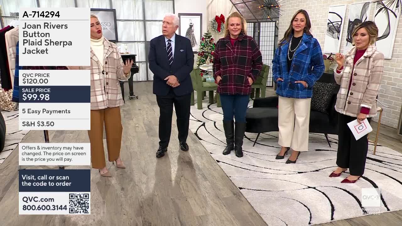 On the QVC3 set, several women and a man stand in front of a curved rug, each wearing a different plaid jacket. A presenter points to a small card while talking, and the screen displays the item's price.
