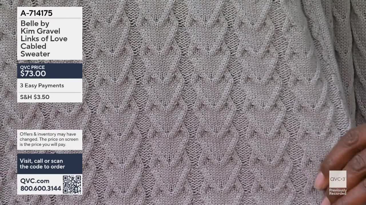 A hand with dark skin reaches into the frame, its fingers brushing against the intricate knit of a taupe sweater. The sweater displays a repeating pattern of raised, diamond-shaped cables, reminiscent of linked hearts.