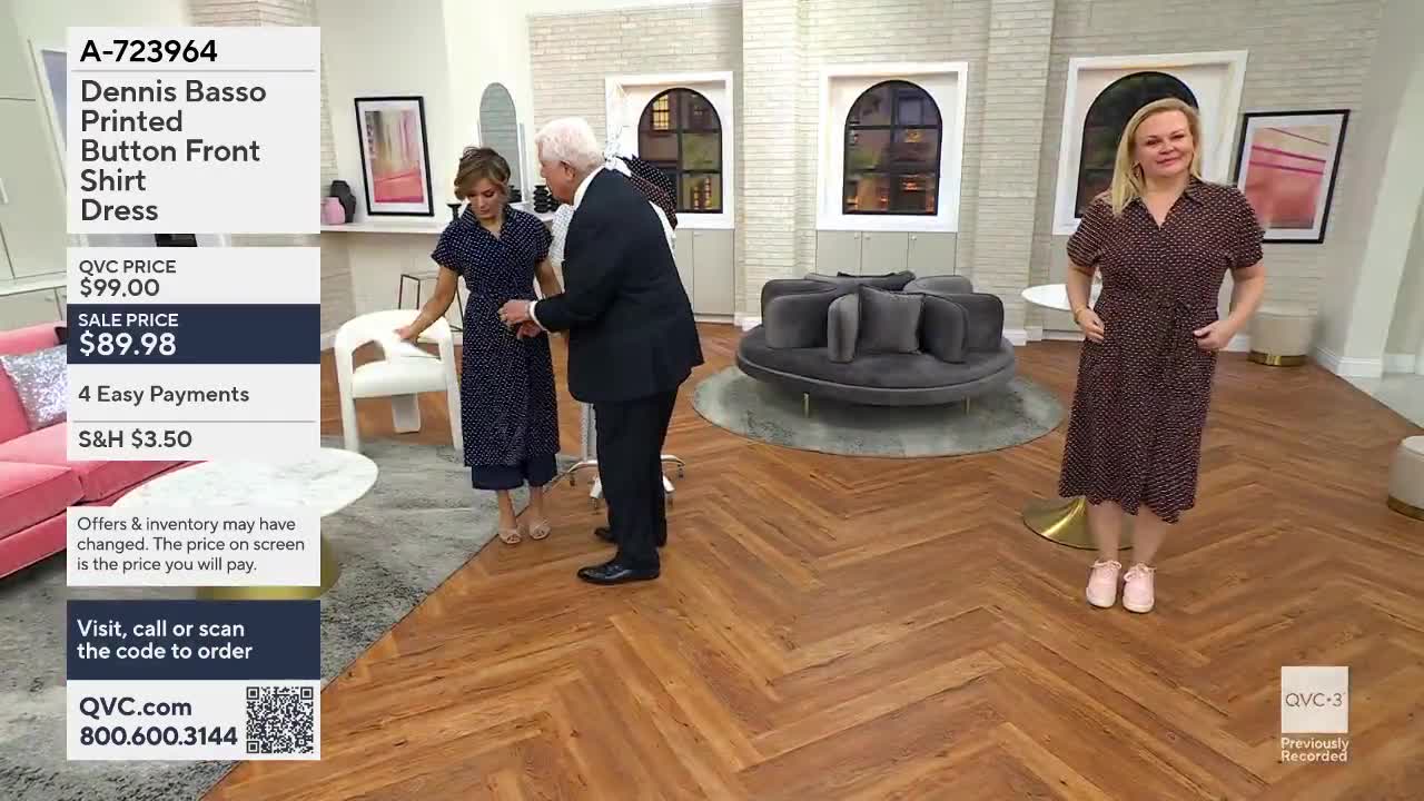 A man in a suit adjusts a woman's navy polka dot dress. Another woman stands nearby, also wearing a polka dot dress.