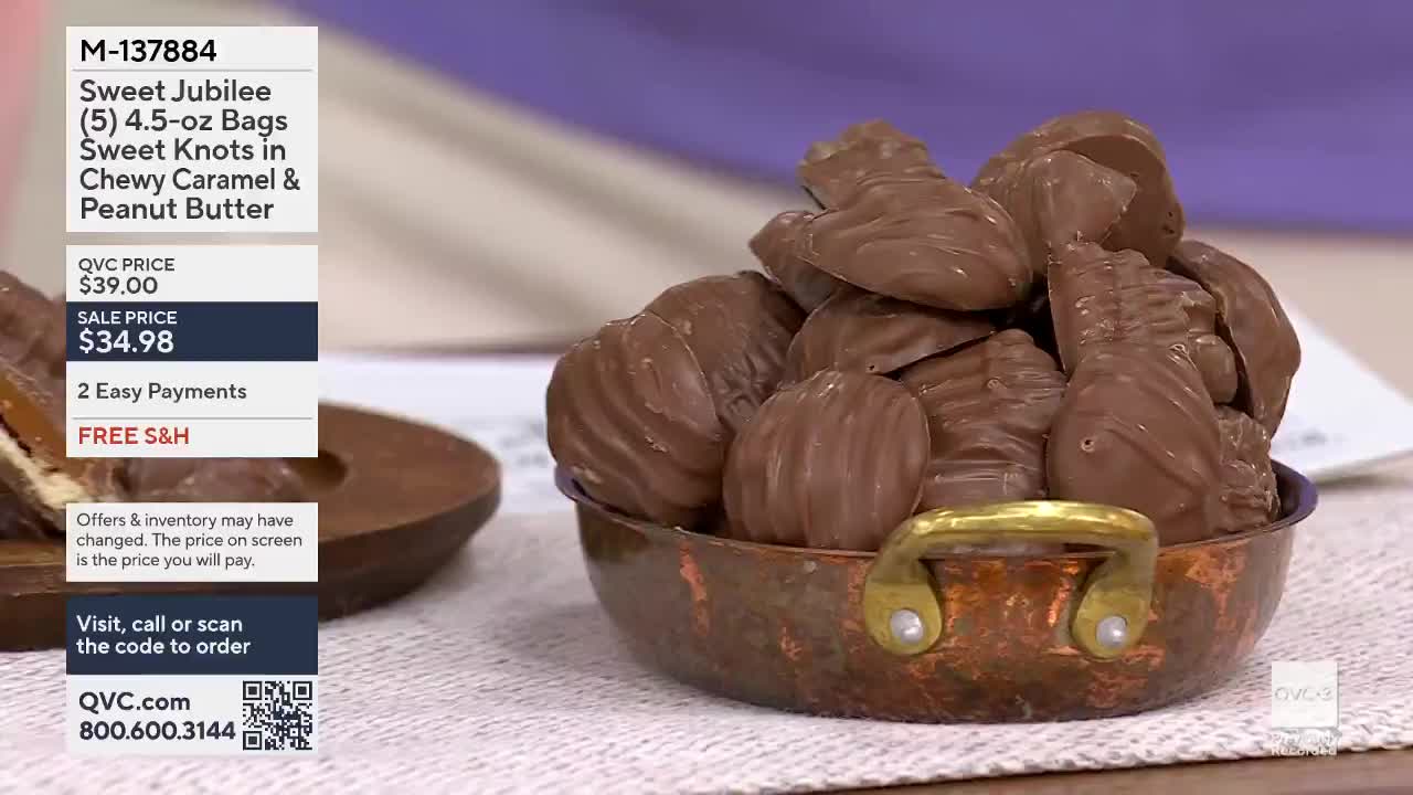 A copper bowl overflows with individually wrapped chocolates. The candies have a ridged texture and are piled high, some showing hints of caramel filling.