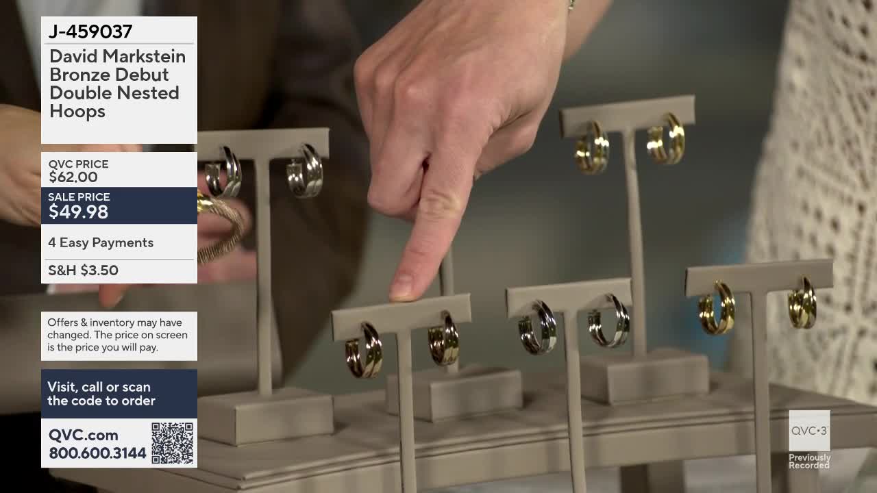A hand points to a display of nested hoop earrings on QVC3. The earrings are arranged in pairs on stands, some in silver tones and others in gold.