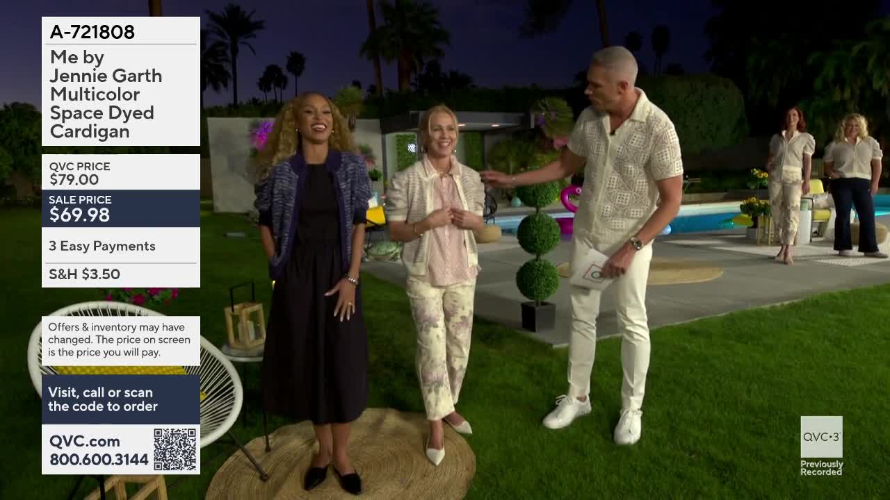 A woman in a dark dress and a patterned jacket laughs as a man in a textured shirt and white pants gestures. Another woman in a light-colored jacket and patterned pants stands between them.