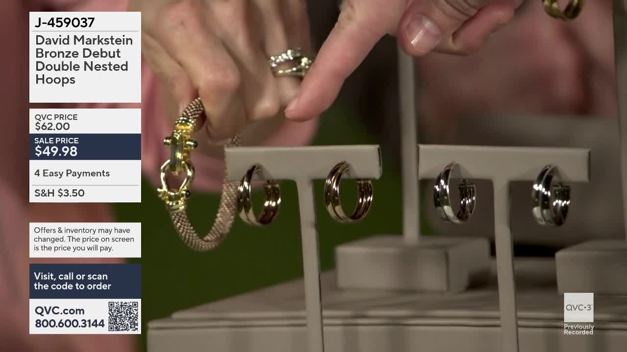 A hand points to a pair of nested hoop earrings on display. Another hand holds a bracelet with a textured band and a clasp.